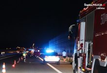 Na zdjęciu miejsce wypadku na autostradzie A1 , widoczny policyjny radiowóz na sygnale, policjant w trakcie czynności i wóz strażacki