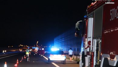 Na zdjęciu miejsce wypadku na autostradzie A1 , widoczny policyjny radiowóz na sygnale, policjant w trakcie czynności i wóz strażacki