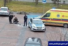 Miejsce zdarzenia. Stojący na placu policjanci obok radiowozu i karetki
