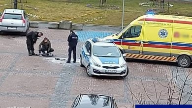 Miejsce zdarzenia. Stojący na placu policjanci obok radiowozu i karetki