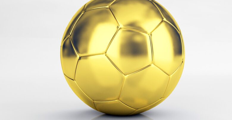 Na zdjęciu złota piłka do piłki nożnej na białym tle