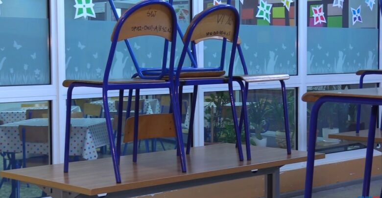 Zdjęcie przedstawia dwa krzesła koloru niebieskiego z drewnianym siedziskiem i oparciem, postawione na szkolnej ławce