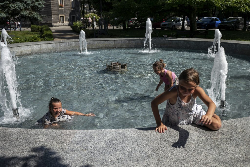 Sierpień. Dzieci kąpią się w fontannie przed Urzędem Miejskim w Bytomiu.