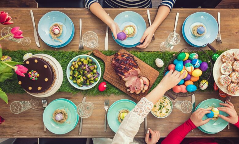 savoir-vivre przy wielkanocnym stole zastawionym potrawami. Widoczne ręce gości obierające jajka