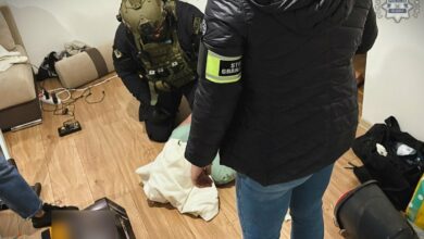 organizowana grupa przestępcza pseudokibice Ruchu Chorzów - policjanci nad zatrzymanym mężczyzną leżącym na podłodze