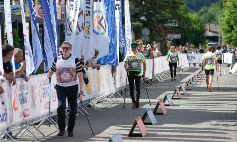 26. Bieg po Nowe Życie w Wiśle uczestnicy trzy osoby maszerują w równych odstęach z kijkami
