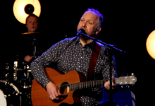 Mateusz Szymczyk - mężczyzna na scenia z gitraa śpiewa piosenkę