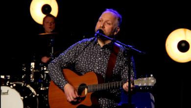 Mateusz Szymczyk - mężczyzna na scenia z gitraa śpiewa piosenkę