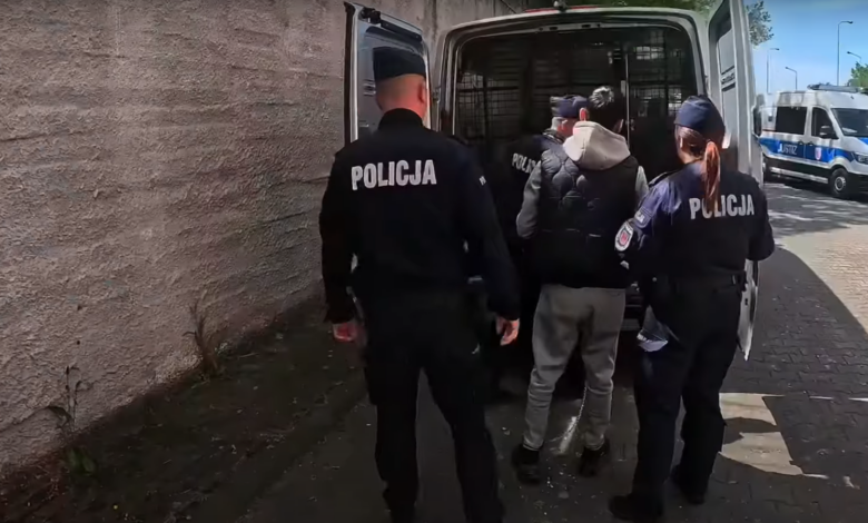 Handel Ludźmi Katowice policjanci prowadzą zatrzymanego mężczyznę do samochodu