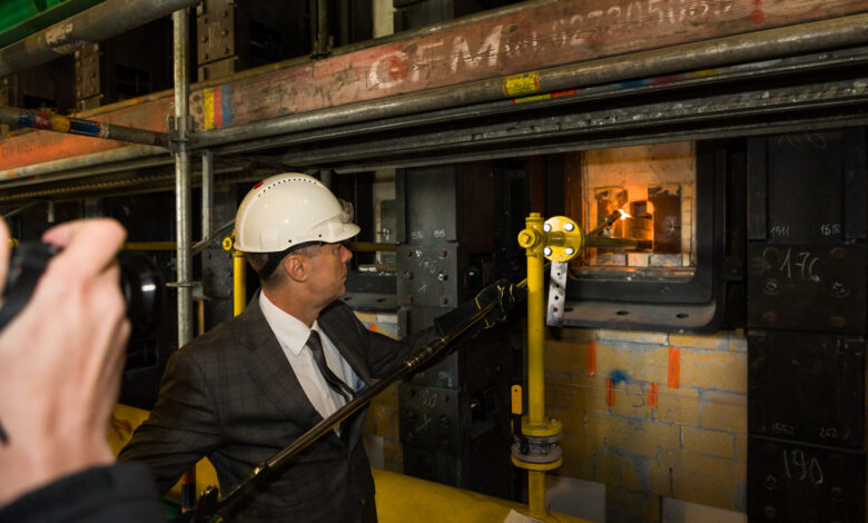 Koksownia Przyjaźń uruchamia najnowocześniejszą baterię koksowniczą w Europie, mężczyzna rozpala palenisko w piecu koksowniczym