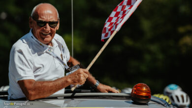 Tour de Pologne mężczyzna z flagą startową w odkrytym samochodzie