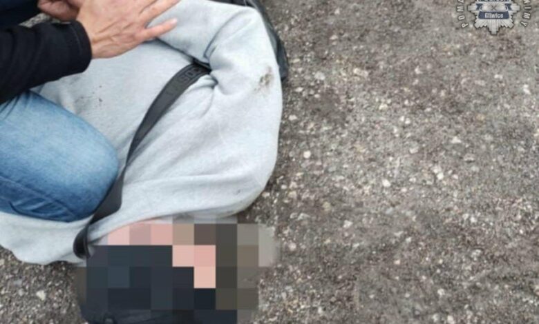 kradzieże samochodów Śląsk - mężczyzna zatrzymany lezy na ziemi trzymany przez policjanta