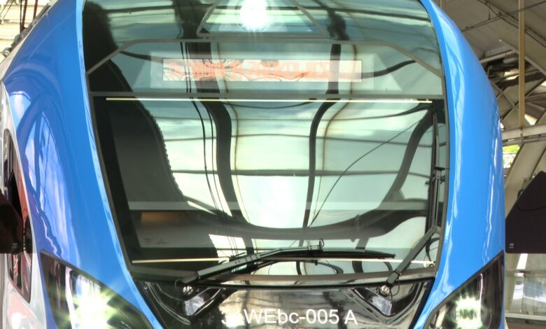 Nowoczesne, wygodne i w pełni elektryczne – Koleje Śląskie właśnie zyskały nowe składy! W środę, 31 lipca 2025 roku, na stacji w Gliwicach zaprezentowano dwa nowe pociągi Impuls 2, które już niebawem ruszą w trasę z pasażerami. Nowe pociągi Kolei Śląskich już gotowe To część ogromnego projektu wartego blisko miliard złotych, finansowanego z programu „Fundusze Europejskie dla Śląskiego”. Łącznie na tory województwa śląskiego trafią aż 26 nowoczesnych Impulsów 2, a dołączą one do pięciu składów zamówionych bezpośrednio przez przewoźnika. Flota Kolei Śląskich zwiększy się tym samym o połowę! – Nowe pociągi oznaczają większy komfort podróżowania i zachętę, by zrezygnować z samochodu na rzecz kolei – podkreślił podczas prezentacji w Gliwicach Grzegorz Boski, wicemarszałek Województwa Śląskiego. Komfort i technologia na pierwszym planie Nowe czteroczłonowe pociągi Impuls 2 rozwijają prędkość do 160 km/h. Na pokładzie znalazło się 400 miejsc dla pasażerów, w tym 192 siedzące. Nie zabrakło także: stref dla rodzin z dziećmi, przestrzeni na 10 rowerów, udogodnień dla osób z niepełnosprawnościami, nowoczesnego systemu informacji pasażerskiej w trzech językach. To wszystko przy energooszczędnym oświetleniu LED i ekologicznej technologii napędu. Więcej pociągów jeszcze w tym roku Już w sierpniu i wrześniu na tory wyjadą kolejne cztery składy zamówione przez województwo, a w grudniu dołączą do nich jeszcze dwa z zamówienia Kolei Śląskich. W sumie kontrakty zawarte z firmą Newag z Nowego Sącza opiewają na 31 składów o łącznej wartości 1,5 miliarda złotych (wraz z serwisem technicznym). – To największa inwestycja taborowa w historii spółki. Dziękujemy pasażerom za zaufanie – zaznaczył Krzysztof Klimosz, prezes Kolei Śląskich - Impuls 2 przód pociągu