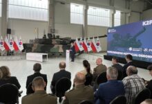 czołgi K2PL produkowane w Gliwicach hala w tle czołk i flagi białoczerwone, grupa osób podczas uroczystego spotkania