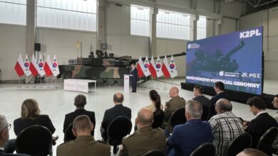 czołgi K2PL produkowane w Gliwicach hala w tle czołk i flagi białoczerwone, grupa osób podczas uroczystego spotkania