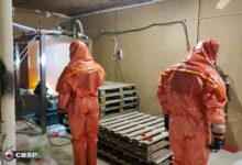 fabryka narkotyków dwie osoby w specialistycznych skafandrach przeszukują pomieszczenie