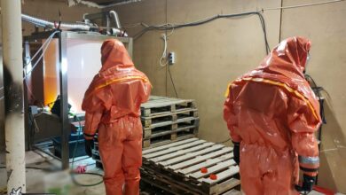 fabryka narkotyków dwie osoby w specialistycznych skafandrach przeszukują pomieszczenie