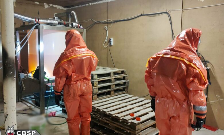 fabryka narkotyków dwie osoby w specialistycznych skafandrach przeszukują pomieszczenie