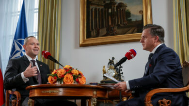 Dwóch męzczyzn rozmawia przy stole Prezydent Karol Nawrocki w Radiu ZET