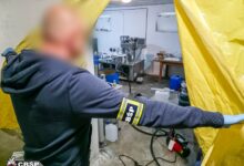 Policjant wchodzi do pomieszczenia i odsłania kotarę