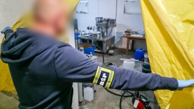 Policjant wchodzi do pomieszczenia i odsłania kotarę