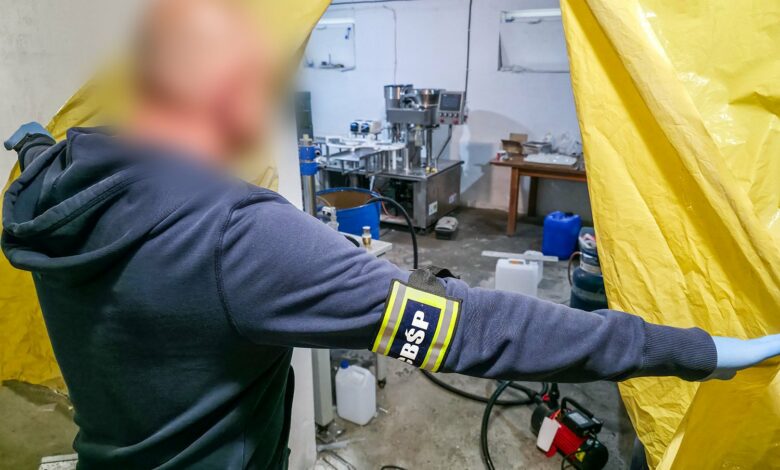 Policjant wchodzi do pomieszczenia i odsłania kotarę