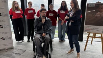 DOm aniołów Stróżów, Grupa ludzi wokół mężczyzny na wóżku