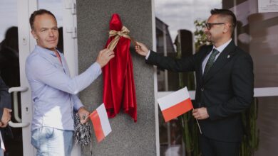 Miniaturowe Rzeźby w Żarkach odsłonięcie rzeźby dwóch męzczyzn zdejmuje ze ściany tkanine zasłaniająca rzeźbę