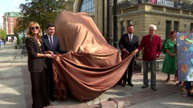 Rzeźba byka Rafała Olbińskiego Katowice gruppa osób zdejmuje płachtę materiału z Byka