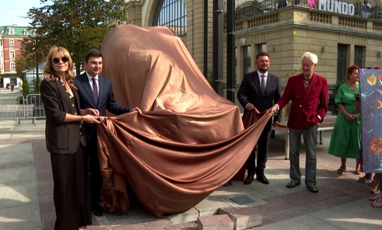 Rzeźba byka Rafała Olbińskiego Katowice gruppa osób zdejmuje płachtę materiału z Byka