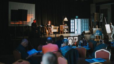 Scena na której na kanapie siedza dwie osoby fragment widowni z widzami