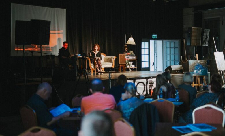 Scena na której na kanapie siedza dwie osoby fragment widowni z widzami