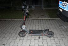 hulajnoga elektryczna obok fragment radiowozu