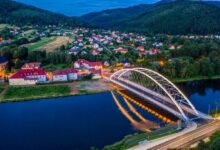 Most nad rzeką w tle zabudowania