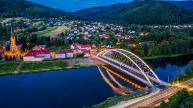 Most nad rzeką w tle zabudowania