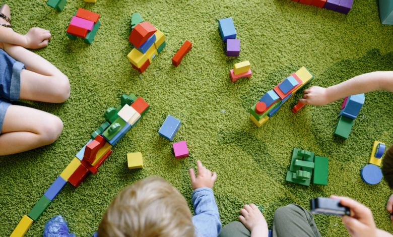 dzieci bawią sie klockami na dywanie