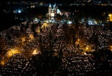 Wszystkich Świętych zmiany w organizacji ruchu w Katowicach - cmentarz nocą z lotu ptaka . widoczny podswietlony kościół i mnóstwo punktów światła płónących zniczy