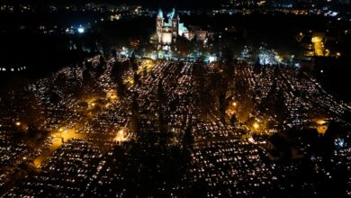 Wszystkich Świętych zmiany w organizacji ruchu w Katowicach - cmentarz nocą z lotu ptaka . widoczny podswietlony kościół i mnóstwo punktów światła płónących zniczy
