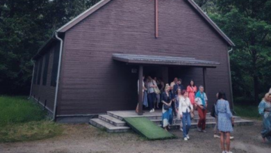 Kościół z drewna a przed nim grupa ludzi