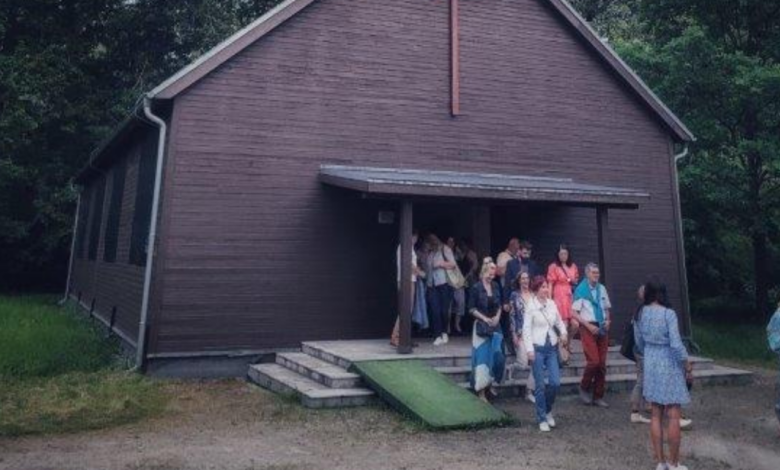 Kościół z drewna a przed nim grupa ludzi