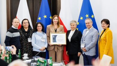 rodziny zastępcze Bielsko-Biała - grupa Osób pozuje do zdjęcia na tle flag unii europejskiej i Polski