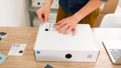 mężczyzna przeklejający etykietę do kartonu