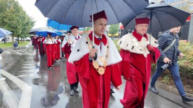 Grupa osób w togach maszeruje ulicą