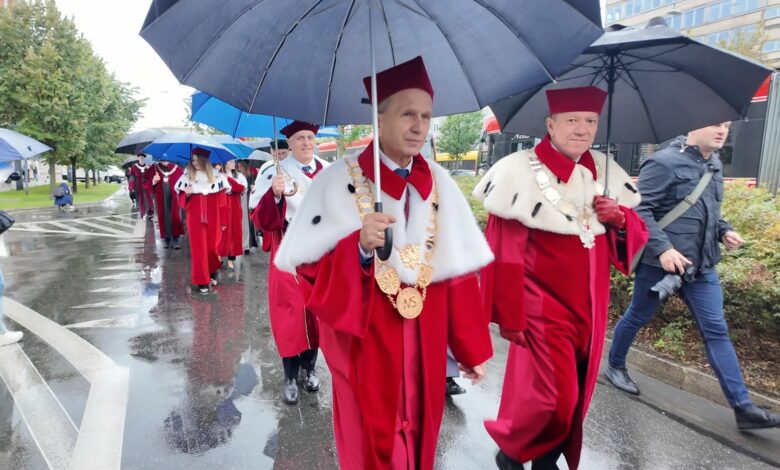 Grupa osób w togach maszeruje ulicą