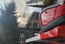 pożar Bielsko-Biała na pierwszym planie drabina wozu strażackiego w tle fragment domu, z którego wydobywa się dym