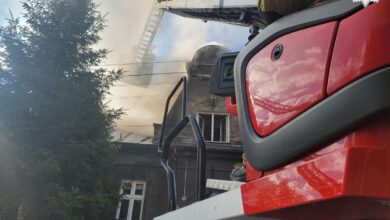 pożar Bielsko-Biała na pierwszym planie drabina wozu strażackiego w tle fragment domu, z którego wydobywa się dym