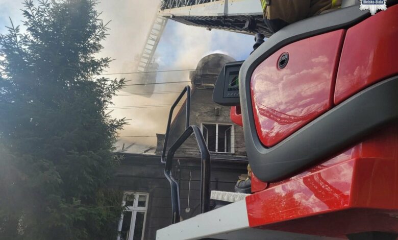pożar Bielsko-Biała na pierwszym planie drabina wozu strażackiego w tle fragment domu, z którego wydobywa się dym